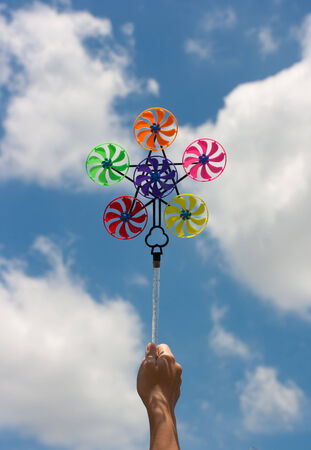 hand hold pinwheel on blue sky backgroundの写真素材