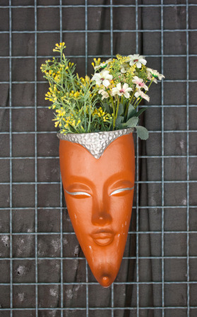 Artificial flowers in pot hang on the wallの写真素材