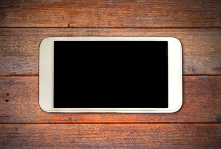 White smart phone with isolated screen on old wooden deskの写真素材
