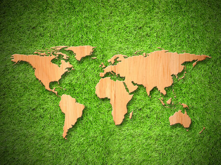 Wood World map on green grass backgroundの写真素材