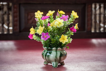 Plastic flower in vase on table.の写真素材