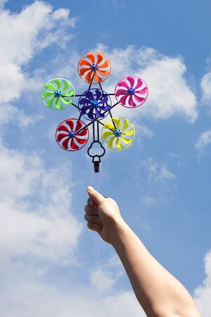 hand hold pinwheel on blue sky backgroundの写真素材