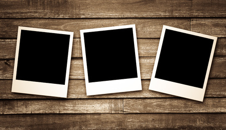 Blank photo frames on wood background - vintage effect filterの写真素材