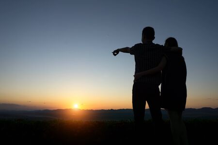 silhouette lovers Hands up against sunset time with lens flareの写真素材