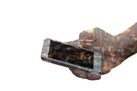 Double exposure of hand hold smartphone over night city background.の写真素材