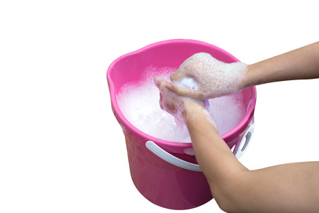 Female Hand washing clothes in the pink basin.の写真素材