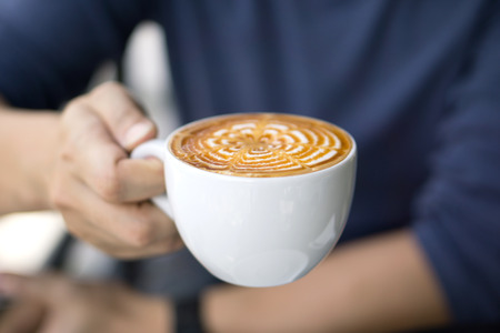 Close-up of male hand holding a cup of coffeeの写真素材
