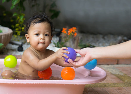 Asian baby boy taking a shower in bathtub