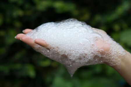 Bubbles in the hands of women and green background