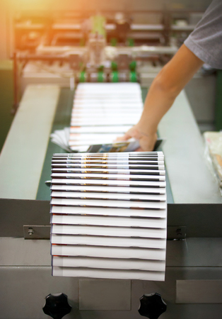 Print shop - Finishing line. Post press finishing line machine: cutting, trimming, paperback.の写真素材