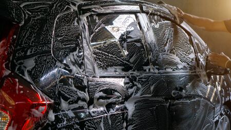 Selective focus of Black Car wash with soap and sunlight filter effectの写真素材