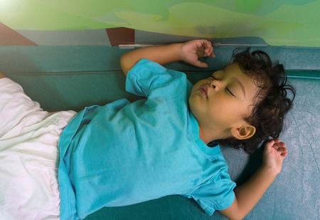 Two years old asian child sleeping on green mattressの写真素材