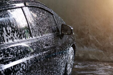 Selective focus of Black Car wash with soap and sunlight filter effectの写真素材