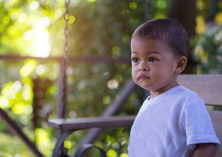 Little asian baby Looking forward in the morning time with nature bokeh background.の写真素材