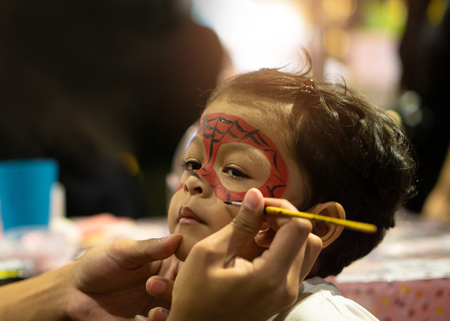 Asian kid boy with painted face as a spider.の写真素材
