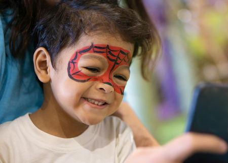 Asian kid boy with painted face as a spider.の写真素材