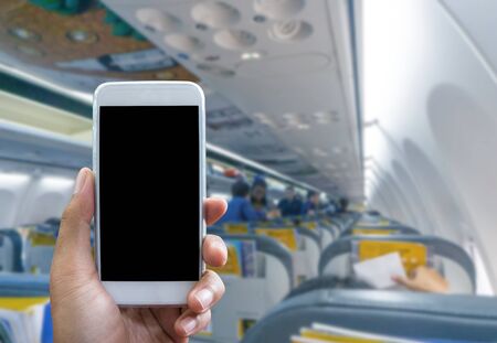 Man use your phone in airplane blurred background - mockup templateの写真素材