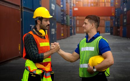 Two cargo workers join hands together for better workの写真素材