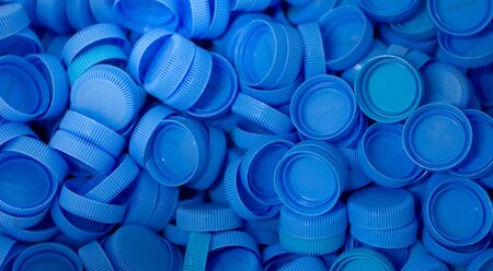 The blue plastic lid that is left over from the bottles are collected to be recycled into other...