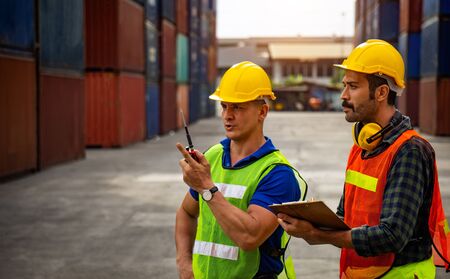 Two industrial workers are discussing the job planning in the shipping industry.の写真素材