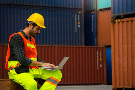 Industrial workers or engineers using computer laptop to control work in logistics business at...