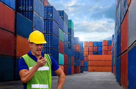 industrial worker is controlling container loading by walkie talkie in import-export business.の写真素材