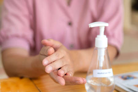 Close Up Asian woman using hand sanitizer by pumping alcohol gel 75% for prevent coronavirus or covid 19.の写真素材