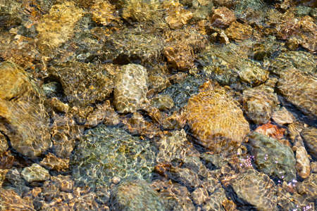 Clear water in the river and stone texture backgroundの写真素材