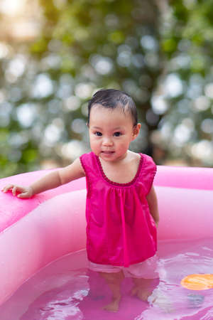 Asian baby girl playing in a baby rubber poolの写真素材