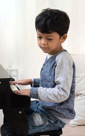 Asian japanese kid learning piano in the classroom.の写真素材