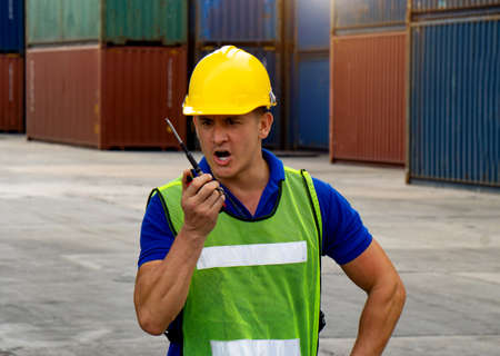 industrial worker is controlling container loading by walkie talkie in import-export business.の写真素材