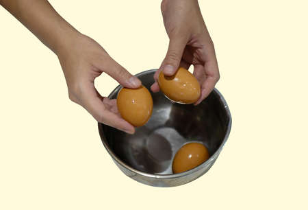 The boiled egg was being shelled  by the woman's hand.の写真素材