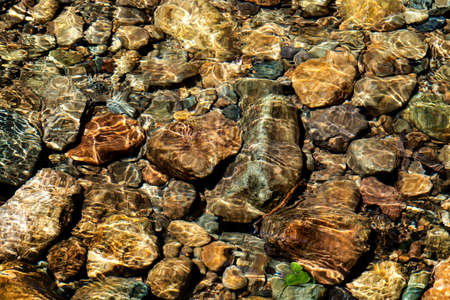 Clear water in the river and stone texture backgroundの写真素材