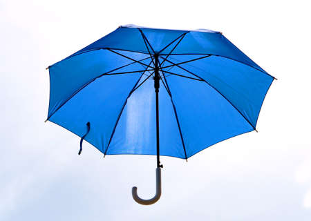 A blue umbrella that was unfolded isolated on white background.の写真素材