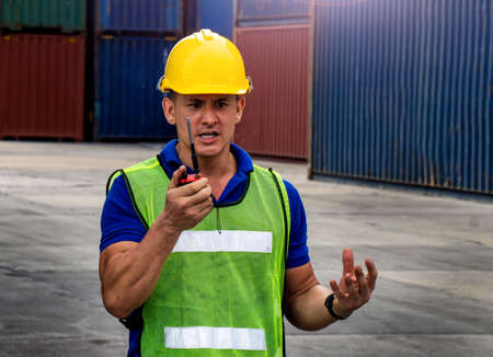 industrial worker is controlling container loading by walkie talkie in import-export business.の写真素材