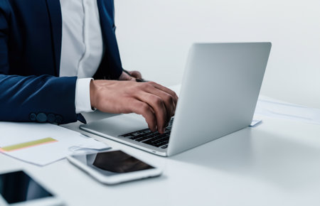 Close-up shot of a businessman using a laptop. Explore the dynamic world of technology, productivity, and professional lifestyle.の素材