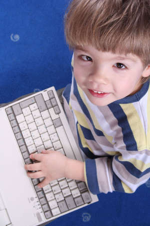 Young boy typing on a laptop computerの写真素材
