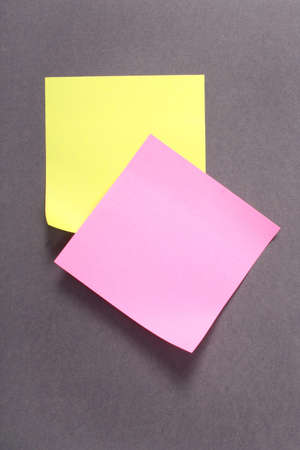 yellow and pink note over grey backgroundの写真素材