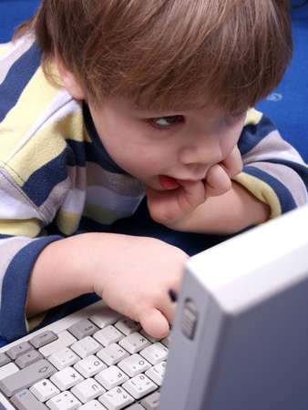 Boy working on a laptop computerの写真素材