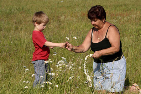 Grandmother and grandson picking flowersの写真素材