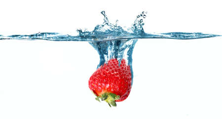 Fresh red strawberry in the blue water with splashの写真素材