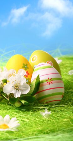 Colorful Easter Eggs and Flowers on Green Grassの写真素材