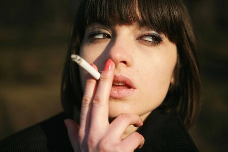 Portrait of a young girl with cigarette. Close-up.の写真素材