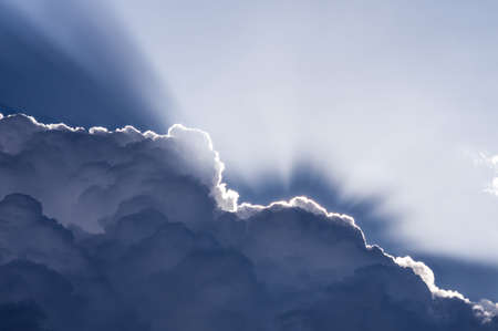 Clouds and Light. Sunlight backlights clouds with blue sky.の写真素材