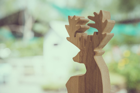 Wooden deer beside window coffee shop with nature garden backgroundの写真素材