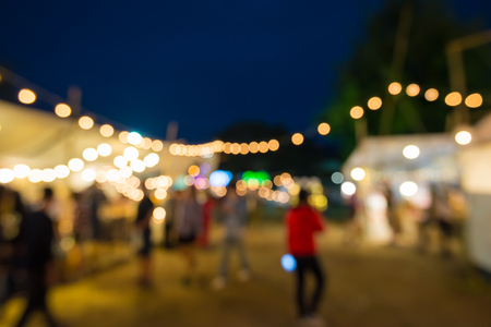 Abstract blur people in night festival city park bokeh background - vintage festival outdoor marketの写真素材