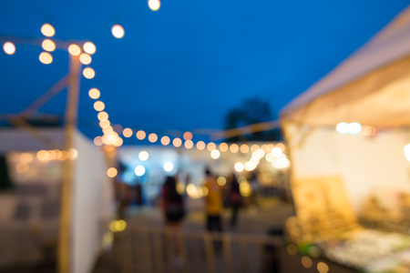 Abstract blur people in night festival city park bokeh background - vintage outdoor festivalの写真素材