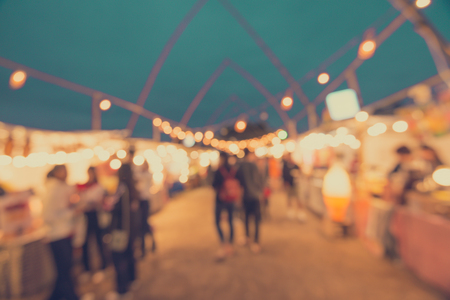 Abstract blur people in night festival city park bokeh background - vintage toneの写真素材