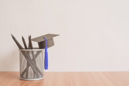 Graducate cap and black pencils on white wall background - Back to school, education conceptの写真素材