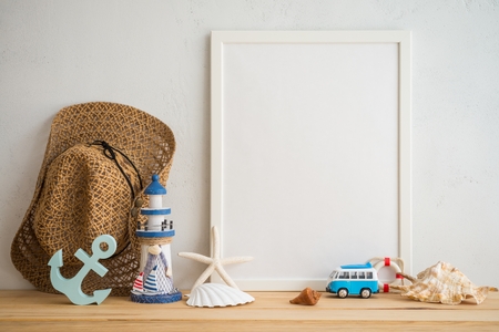 White vintage photo frame on old wooden table over white wall background with beach accessories - Summer tropical beach holiday traveling conceptの写真素材